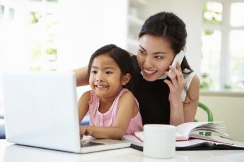 Busy Mother Working From Home With Daughter