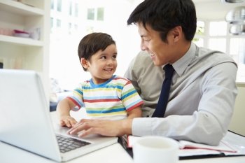 Busy Father Working From Home With Son
