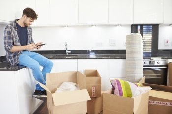 Man Sending Text Message Having Moved Into New Home