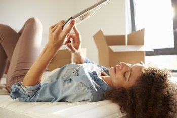 Woman Moving Into New Home Using Digital Tablet