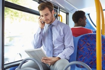 Businessman Using Mobile Phone And Digital Tablet On Bus