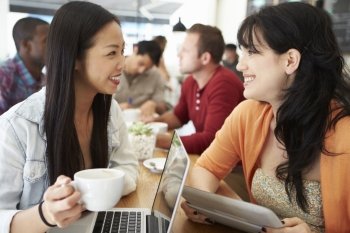 Two Female Friends Meeting In Busy Coffee Shop
