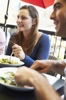 Woman Enjoying Meal At Outdoor Restaurant With Friends