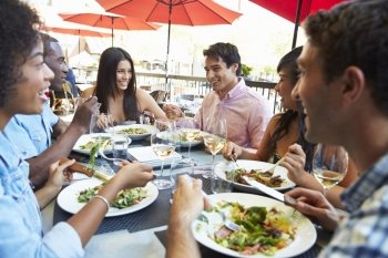 Group Of Friends Enjoying Meal At Outdoor Restaurant