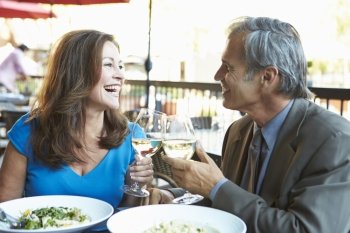 Mature Couple Enjoying Meal At Outdoor Restaurant
