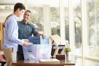 Father Helping Teenage Son Pack For College