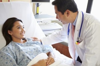 Doctor Talking To Female Patient On Ward