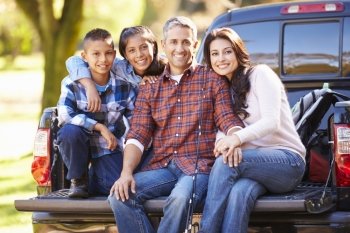 Family Sitting In Pick Up Truck On Camping Holiday