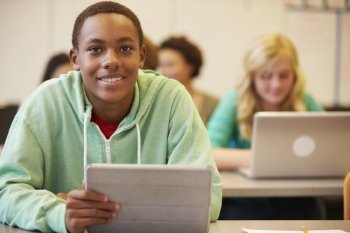 High School Student At Desk In Class Using Digital Tablet