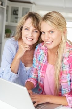 Mother and teenage daughter using laptop