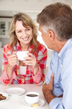 Mid age couple having coffee at home