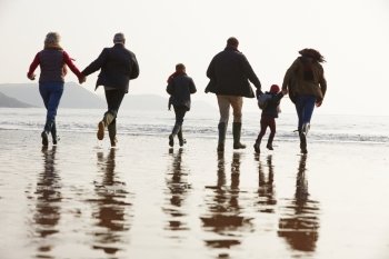 Multi Generation Family Walking On Winter Beach