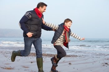 Father And Son Running On Winter Beach