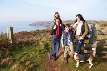 Family With Dog Walking Along Coastal Path