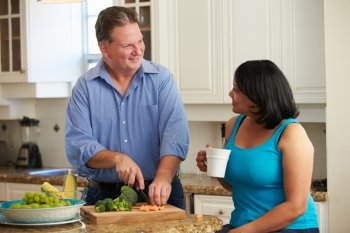 Overweight Couple On Diet Preparing Vegetables In Kitchen