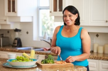 Overweight Woman Preparing Vegetables In Kitchen