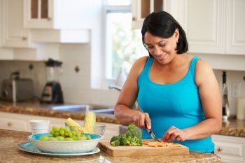 Overweight Woman Preparing Vegetables In Kitchen