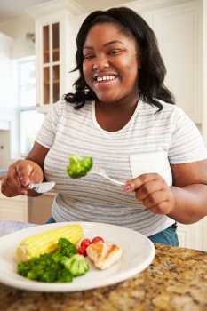 Overweight Woman Eating Healthy Meal in Kitchen