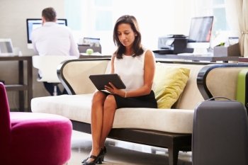 Businesswoman Working On Digital Tablet In Hotel Lobby
