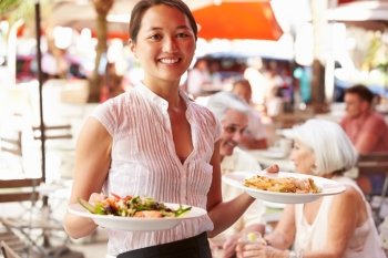 Waitress Serving Food At Outdoor Restaurant