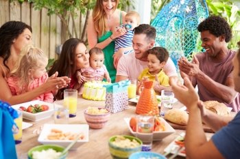 Group Of Families Celebrating Child's Birthday At Home