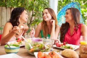 Three Female Friends Enjoying Meal Outdoors At Home