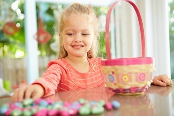 Girl With Chocolate Easter Eggs And Basket At Home