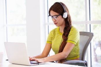 Woman Wearing Headphones Working In Design Studio