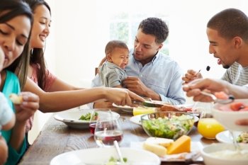 Group Of Friends With Babies Enjoying Meal At Home Together