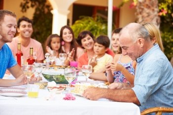 Large Family Group Celebrating Birthday On Terrace Together
