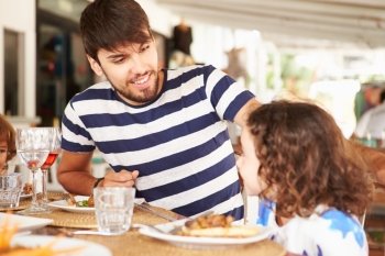 Father And Daughter Enjoying Meal In Restaurant