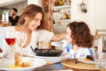 Mother And Daughter Enjoying Meal In Restaurant