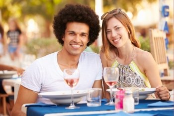 Young Couple Enjoying Meal In Outdoor Restaurant
