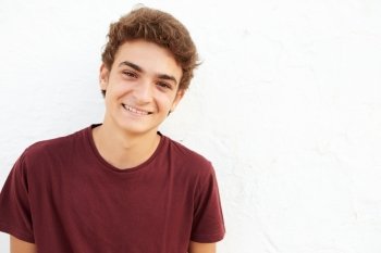 Portrait Of Hispanic Teenage Boy Leaning Against Wall