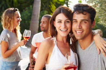 Couple With Friends Drinking Wine And Relaxing Outdoors
