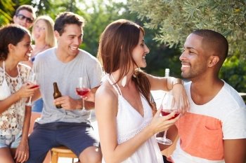 Couple With Friends Drinking Wine And Relaxing Outdoors