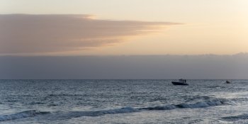 Boat moving in the sea at dusk, Bay Islands, Honduras