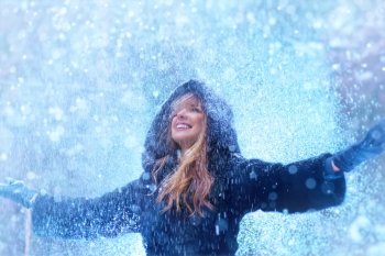Young woman with falling snow winter portrait.