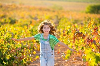 kid farmer  girl running in vineyard field in autumn red leaves
