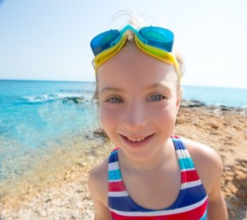 Kid funny girl wide angle beach portrait with swimsuit and swimming goggles