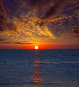 Sunset at Mediterranean sea with orange sky and sun reflection