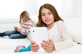 Children sister friends kid girls playing with tablet pc on white sofa