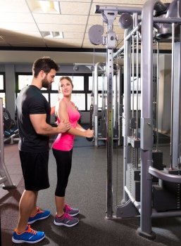 cable pulley system personal trainer man and woman learning at fitness gym