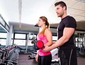 Gym personal trainer man with dumbbell woman fitness weightlifting