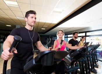 Aerobics elliptical walker trainer group at fitness gym workout