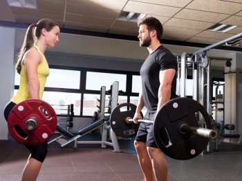 Barbell man and woman workout at fitness gym club
