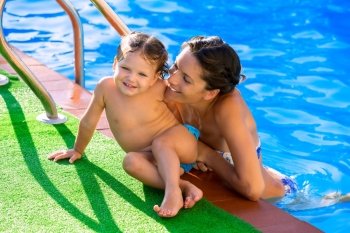 Happy mother and baby daughter girl at swimming pool in summer vacation