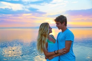 Blond young couple hug in sunset sea lake happy together