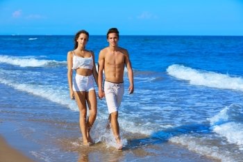 Couple young walking on the beach shore in summer vacation