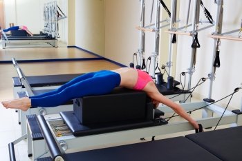 Pilates reformer woman back stroke exercise workout at gym indoor